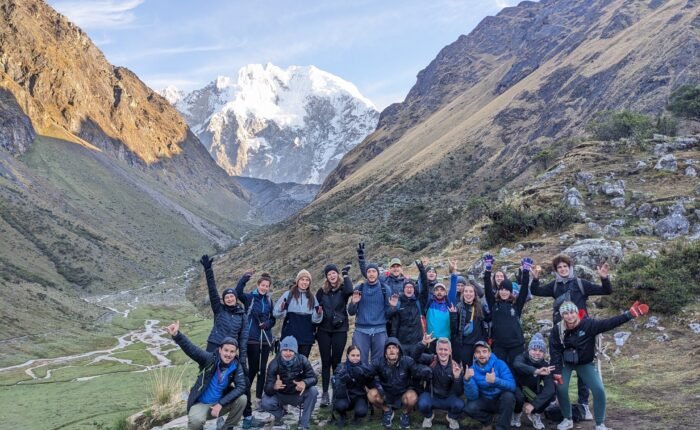 Hikers trekking along the Salkantay Trail to Machu Picchu with snow-capped peaks.