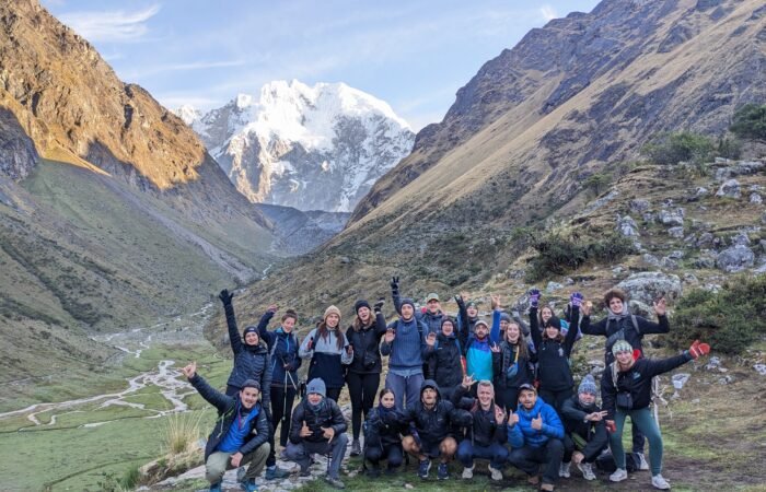 Hikers trekking along the Salkantay Trail to Machu Picchu with snow-capped peaks.