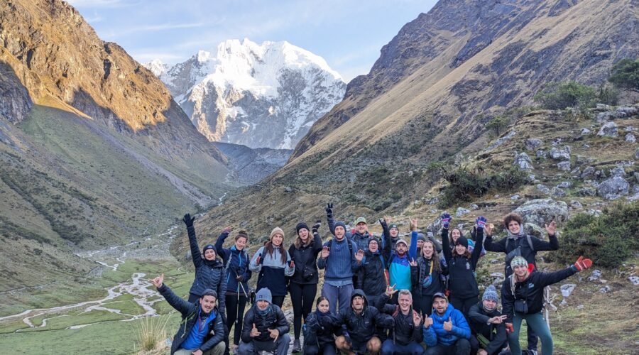 Hikers trekking along the Salkantay Trail to Machu Picchu with snow-capped peaks.