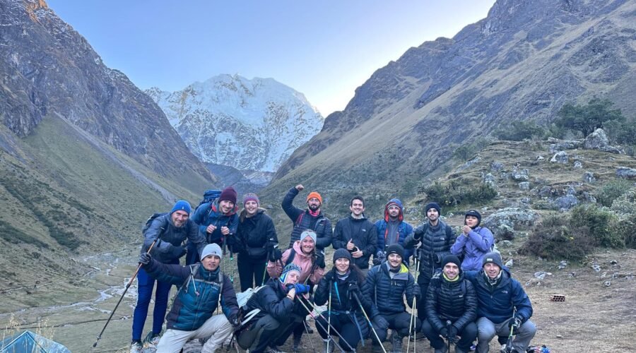 Hikers on the Salkantay Trek passing through high Andean mountains near Salkantay Peak with snow-capped scenery and dramatic landscapes.